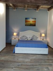 PaglietaAgriturismo Tenuta Villa Catena的一间卧室配有一张带蓝色床单的床和两盏灯。