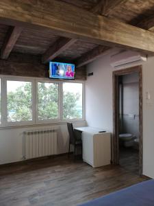 PaglietaAgriturismo Tenuta Villa Catena的客房设有书桌和天花板上的电视。