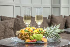 罗马马尔蒂斯宫殿酒店的桌上一篮水果和两杯酒杯