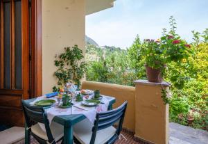 伊斯基亚B&B Lodge dell'Ospite Ischia的鲜花庭院里的一张带椅子的蓝色桌子