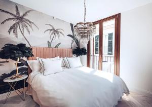马略卡岛帕尔马Ocho Suites & Kitchen的卧室配有一张白色大床和吊灯。