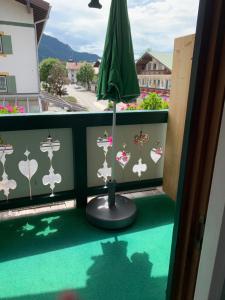 若特阿赫-埃根Ferienwohnung Giacomelli 3的阳台配有绿伞和绿色地板