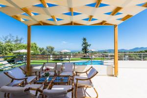 OrthésAnatoli Villa, Tranquil Retreat, By ThinkVilla的一个带桌椅的庭院和一个游泳池