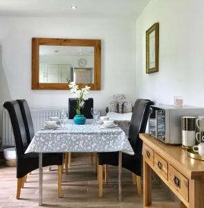牛津The Woodfarm Lodge - 3 Bedroom House with free Parking的一间带桌椅和镜子的用餐室