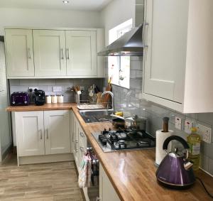 牛津The Woodfarm Lodge - 3 Bedroom House with free Parking的厨房配有白色橱柜和炉灶烤箱。