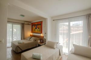 莫罗圣保罗蝴蝶旅馆的一间卧室设有两张床和大窗户