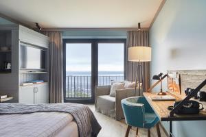 比苏姆Lighthouse Hotel & Spa的酒店客房设有一张床和一张书桌,享有美景。