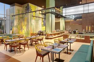 雅加达ibis Styles Jakarta Simatupang的一间带桌椅的用餐室和一间餐厅