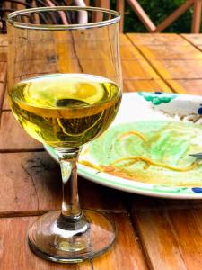 奈瓦沙Kianderi Villa-Great Rift Valley Resort的木桌旁的一杯白葡萄酒