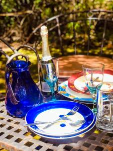 奈瓦沙Kianderi Villa-Great Rift Valley Resort的一张桌子,上面放有盘子和酒杯,还有一瓶