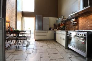 马赛布兰奇别墅酒店的一间厨房,配有白色家电和桌椅