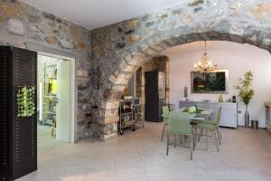 皮吉Muazzo Creta Stone House, a Fairytale Cottage, By ThinkVilla的一间厨房和带石墙的用餐室