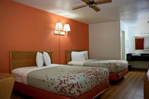 埃尔多拉多Heritage Inn & Suites的橙色墙壁的酒店客房内的两张床