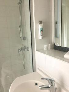 圣但尼宜必思圣丹尼斯体育场奎斯特酒店的浴室配有盥洗盆和带镜子的淋浴