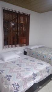 拉米萨Casa guadua piscina privada的一间卧室设有两张床和窗户。