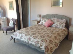 IdenBaron's Grange的一间卧室配有一张床和一把椅子