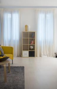 威尼斯Uma Apartments的客厅配有黄色沙发和白色窗帘