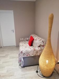 兰佐丁泰尔维La casa di Beppe c cir D1135的一间卧室配有一张带红色枕头和花瓶的床
