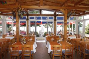 利缇纳Pension Villa Rosa的餐厅设有木桌、椅子和窗户。