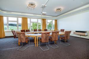 Hagen布勒兰德酒店的一间会议室,配有大桌子和椅子