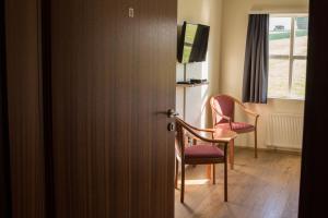 埃基斯蒂尔斯基帕來库尔旅馆的配有两把椅子和窗户的开放式门