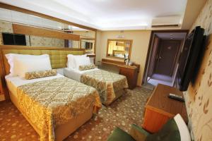 伊兹密尔大转角精品酒店的酒店客房设有两张床和电视。