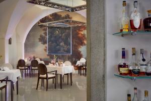 Herálec欧舒丹赫拉莱茨城堡精品酒店及水疗中心的用餐室配有桌椅,墙上挂有绘画作品