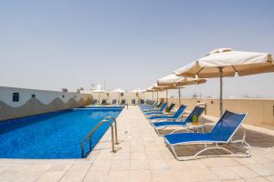 迪拜迪拜投资公园普瑞米尔酒店的游泳池旁的一排椅子和遮阳伞
