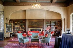 伯克利伯克利城市俱乐部酒店的图书馆配有椅子、桌子和书架