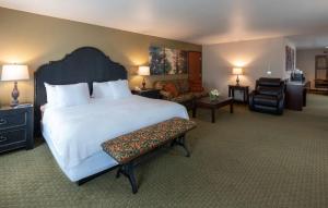 草谷Gold Miners Inn Grass Valley, Ascend Hotel Collection的酒店客房带一张大床和一把椅子