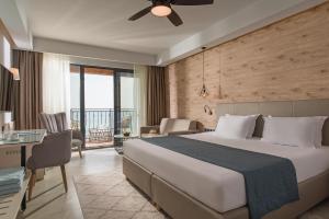 克兰内沃Effect Algara Beach Resort - Ultra All Inclusive and Free Parking的酒店客房设有一张大床和一张书桌。