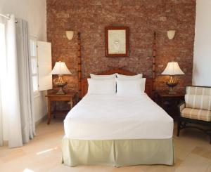 费拉希腊乐培迪酒店的一间卧室配有一张带两盏灯的大型白色床。
