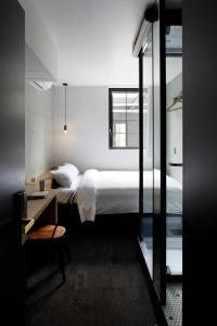 东京HOTEL CEN的一间卧室配有一张床、一张书桌和一个窗户。