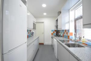 特伦特河畔斯托克Lexicon House - 4 bedrooms 3 bathrooms的厨房配有白色橱柜和水槽