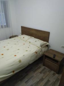 MustăţeştiPensiunea Luminita的一间卧室配有床和木制床头柜