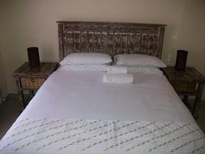 比勒陀利亚Koiketla Guesthouse的一张带两个枕头的白色床和两张