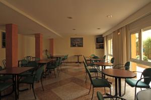 圣费柳-德帕利亚罗尔斯方达芬耐酒店的客房设有桌椅和窗户。