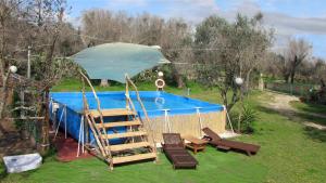 库特罗菲安诺Camping Terreno-Ro-Bi-Li的一个带梯子和遮阳伞的游泳池
