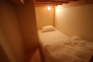 富士市Running Bare的一间小房间,里面设有白色的床