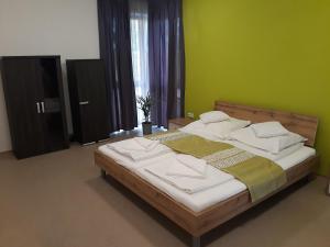 莫劳豪洛姆Bella Vendégház Mórahalom的一间卧室设有一张带绿色墙壁的大床