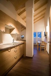 维尔德科格尔山麓布兰贝格ff Appartements的一间带木制橱柜的厨房和一间带桌子的用餐室