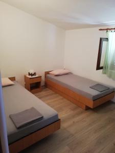 穆泰尔岛Apartman Dino的客房设有两张床,铺有木地板。