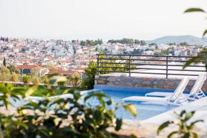 斯基亚索斯镇Amira的一个带两把椅子的游泳池,享有城市美景