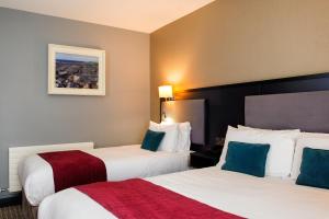 利斯坎诺墨赫尔崖酒店的酒店客房设有两张床,墙上挂有绘画作品