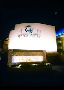 町田市WATER HOTEL Cy (Audlt Only)的夜间水塔前的标志