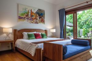 甲米镇Baan Pinya Balinese Style Pool Villa的一间卧室设有一张床和一个大窗户