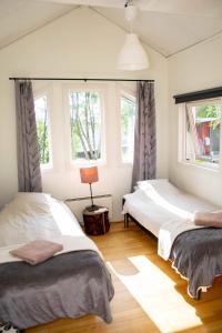 基律纳Husky Lodge Hostel的带2扇窗户的客房内的2张床