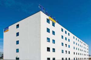 梅里尼亚克波尔多梅里尼亚克特内奥公寓式酒店的一座白色的建筑,上面有梯子