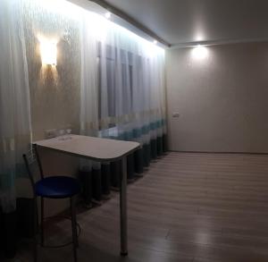 扎波罗热проспект Соборный Автовокзал的配有桌子和蓝椅的房间