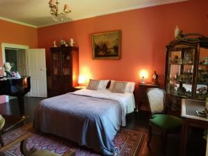 SauvillePresbytere的一间拥有橙色墙壁的卧室和一张位于客房内的床